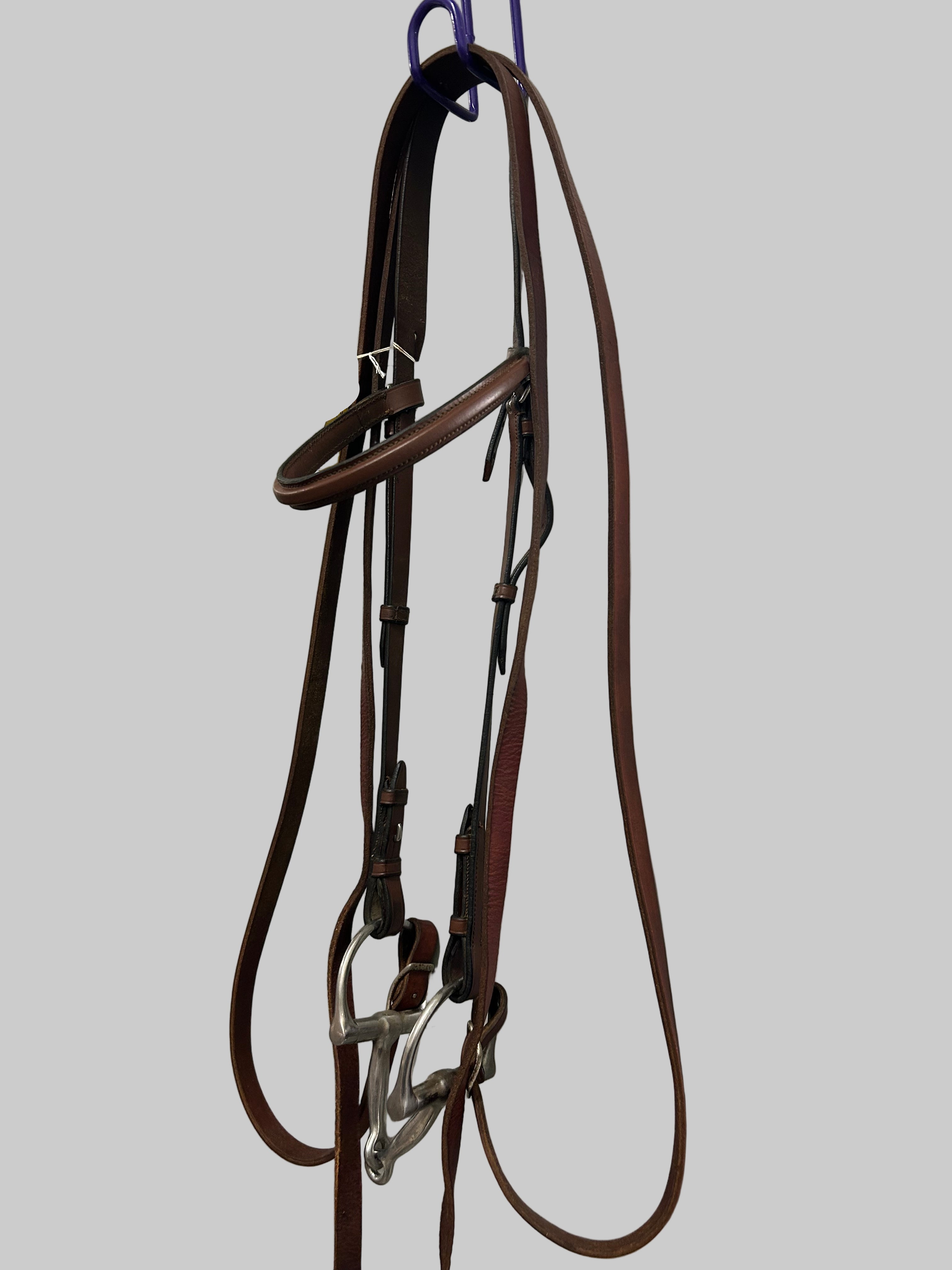 Brown leather bridle on a white surface