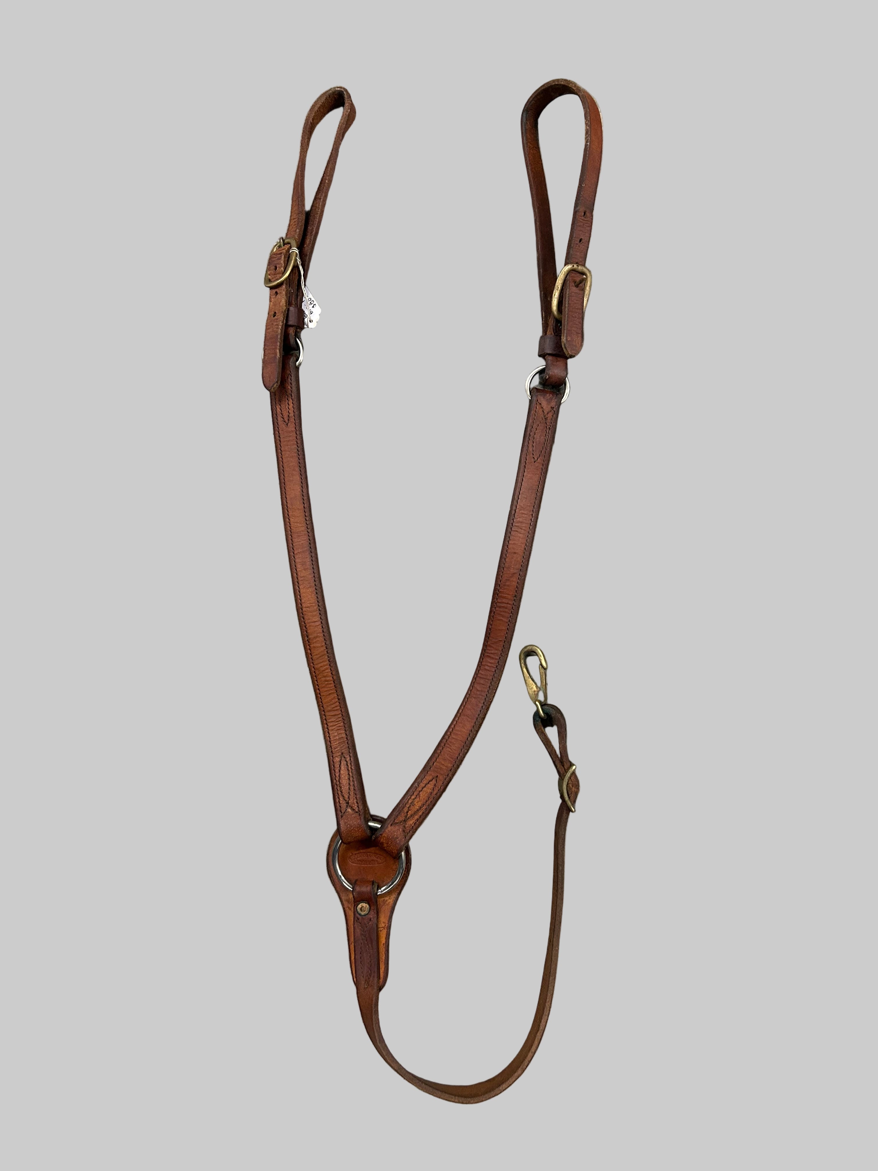 Brown leather breast collar on a tiled floor