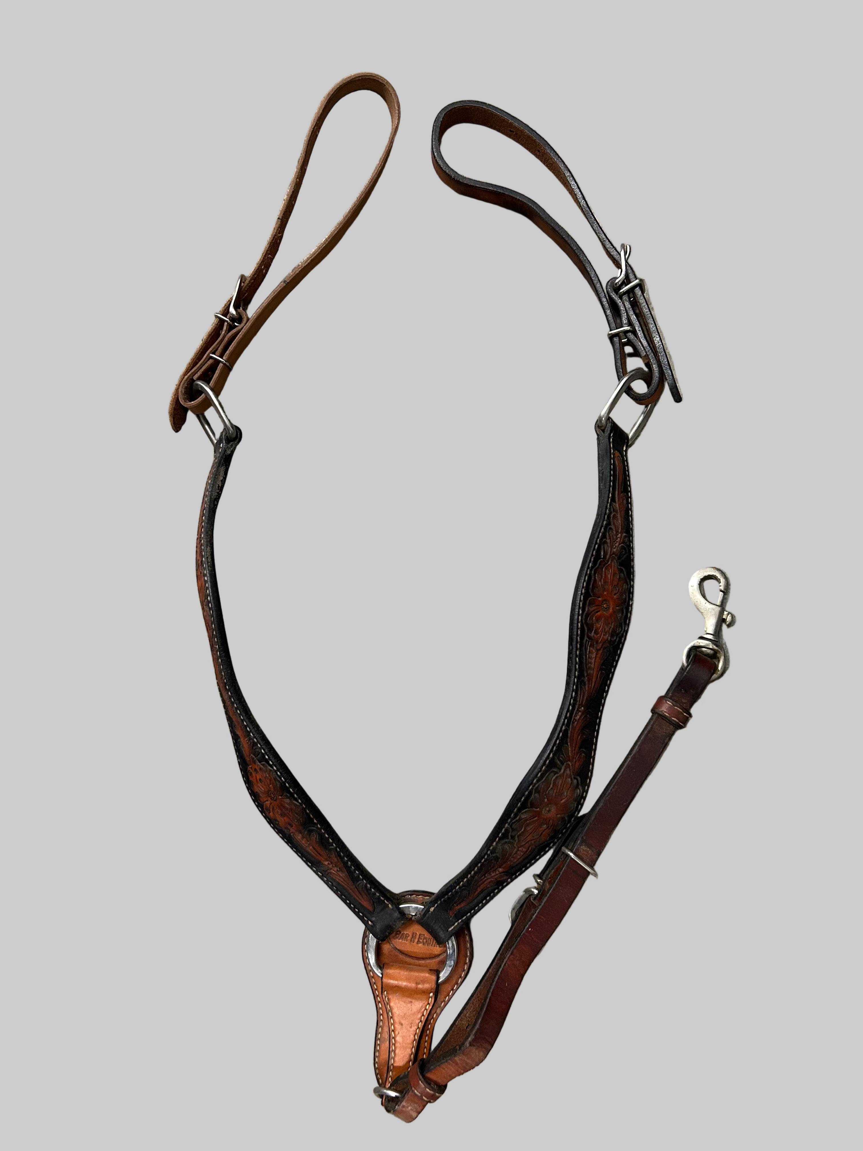 Brown leather bridle on a gray tiled floor