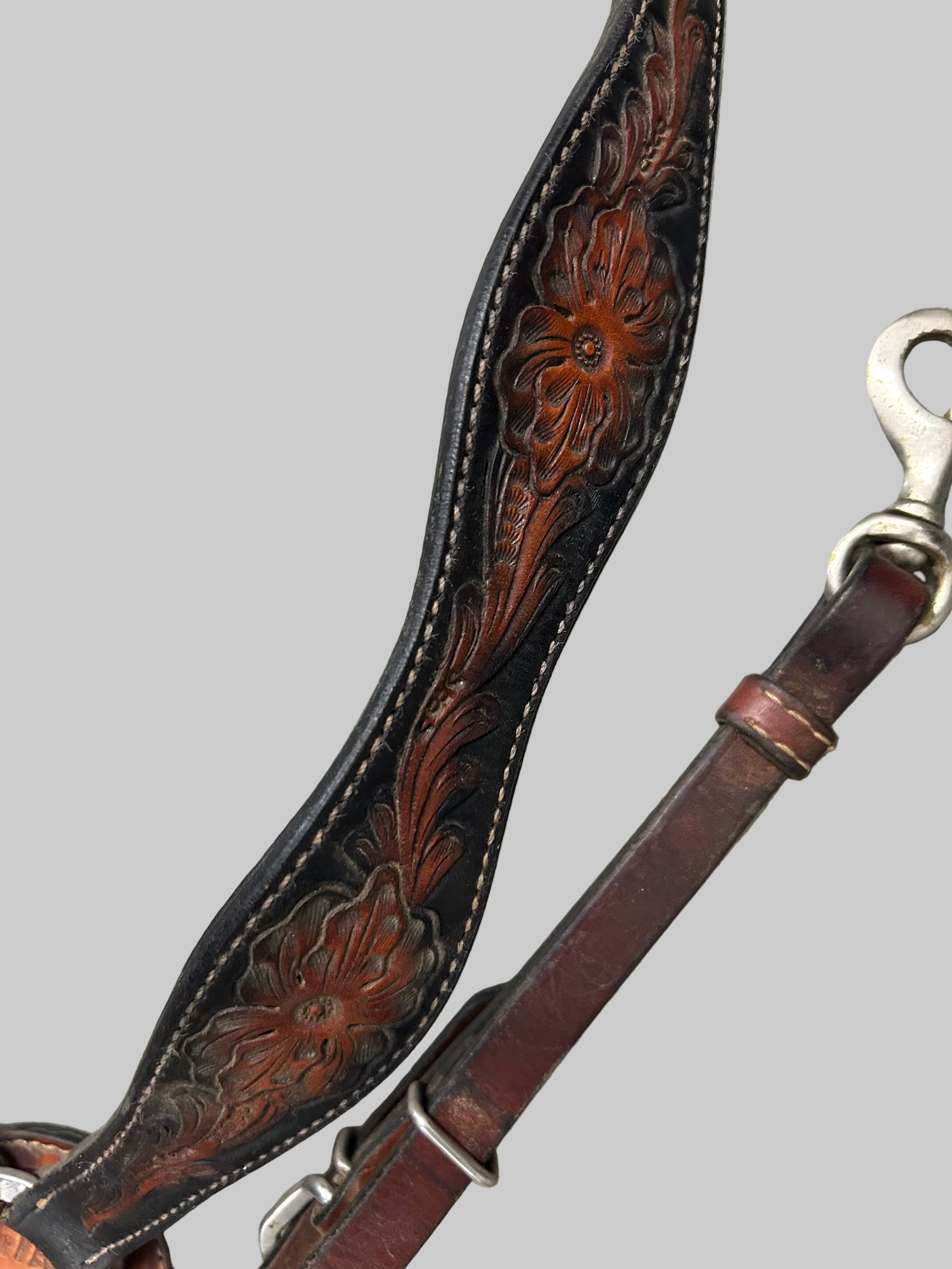 Brown leather breastplate with floral patterns on a stone surface